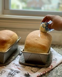 two loafs of bread sitting on top of a counter next to each other in pans