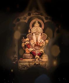 an elephant statue sitting on top of a wooden table next to a wall with lights in the background