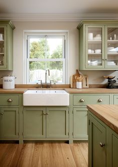 a kitchen with green cabinets and wooden floors