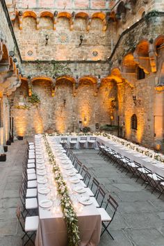 an indoor venue with tables and chairs set up for a formal function in the evening