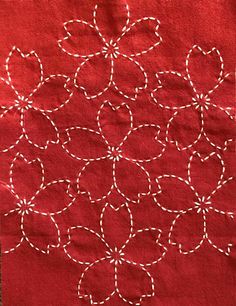 a red piece of cloth with white stitching on it and circles in the middle