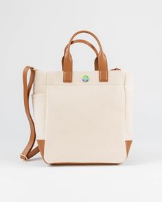 The Cape Code Tote is a truly elevated and refined take on the classic design. The design featured dual handles and a detachable strap for convenience. The spacious interior will fit all your daily needs and even works as a weekender or picnic bag. The streamlined style complements any outfit and works for his, hers, and theirs. • Natural/Saddle • 100% cotton with leather trim • Unlined • Two exterior side pockets • Leather bottom • Detachable & adjustable strap • 6” handle drop • Measures 11.5” Everyday Weekender Bag With Top Handle And Adjustable Strap, Weekender Bag With Leather Handles And Double Handle, Everyday Travel Bag With Top Handle And Leather Details, Everyday Travel Bag With Double Handle, Weekender Bag With Double Handle For Everyday Use, Everyday Weekender Tote Bag With Detachable Strap, Classic Beige Weekender Bag With Double Handle, Rectangular Weekender Bag With Detachable Strap For Everyday Use, Coated Canvas Bag With Detachable Handle