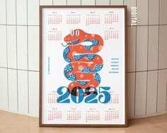 a red and blue snake is sitting on the wall next to a calendar with numbers