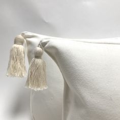 a white pillow with tassels on it