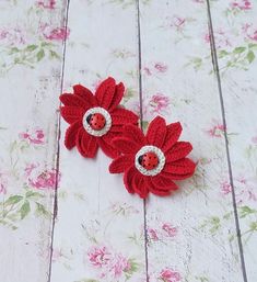 two red crocheted flowers with ladybugs on them sitting next to each other