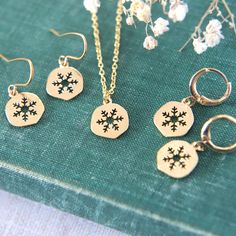 "A delightful collection of winter themed gold plated snowflake jewellery. Choose between a necklace, huggie hoop earrings or earwire earrings. The shiny snowflake charms are lightly textured and are perfect to add that wintery detail to any outfit.  The snowflake charms measure 1cm tall (0.4\"). If you are selecting the necklace option, please also select the chain length you would like from the drop down menu.  All materials are gold plated brass. Delivered to you gift boxed ready to give as a Christmas Jewelry Gift For Her, Snowflake Jewelry For Holiday Gifts, Holiday Snowflake Jewelry For Gift, Snowflake Shaped Holiday Jewelry Gift, Holiday Snowflake Jewelry Gift, Snowflake Shaped Holiday Gift Jewelry, Sterling Silver Jewelry For Winter Gifts, Christmas Jewelry Set As Gift With Matching Earrings, Christmas Jewelry Gift With Matching Earrings