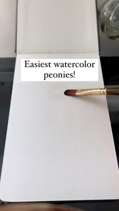 an easel watercolor pen sitting on top of a white piece of paper with the words easiet watercolor peonies