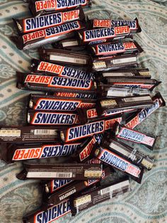 a pile of snickkers sitting on top of a bed next to each other