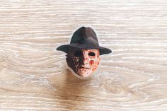 a mask with a hat on top of a wooden table