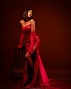 a woman in a red dress sitting on a chair