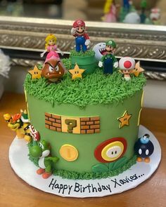 a green birthday cake with mario and friends on top