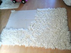 a white rug is laying on the floor next to a toy truck and other items