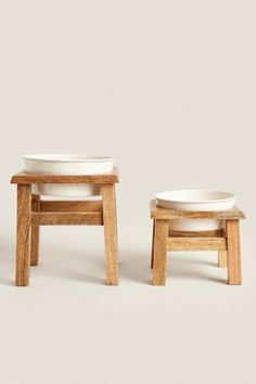 two wooden stools with white bowls on them