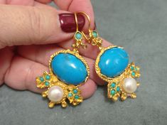 Gold plated brass earring  with blue howlite and pearl .  chandelier earrings .Turkish jewelry Antique reproduction of ottoman style handmade turkish classic earrings  Its light weight 2,5cm width 5,5 cm length dangle Styles It is hipoallergenic. It does not contain cadmium, nickel or cadmium. It is packed in a smart gift black bag with a fancy golden color envelope and an organza black bag to keep in your jewelry box or carry them. An extra pair of nuts is given as a beybiju gift. Please write Elegant Handmade Turquoise Chandelier Earrings, Handmade Turquoise Chandelier Earrings, Gemstone Earrings Dangle, Smart Gift, Classic Earrings, Turkish Jewelry, Golden Color, Brass Earrings, Chandelier Earrings