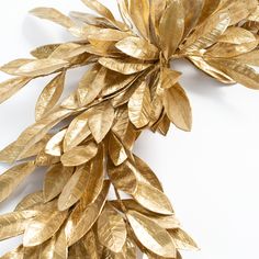 gold leaves are arranged on a white surface