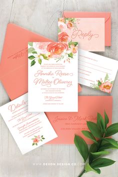 an orange and pink wedding suite with flowers on the front, two matching envelopes