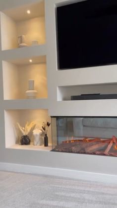 a tv mounted on the wall above a fire place in a room with white walls