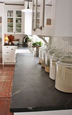 there are many jars on the counter in this kitchen