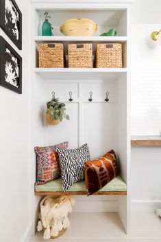 a white shelf filled with lots of pillows next to baskets on top of each other