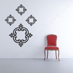 a red chair sitting in front of a wall with an ornate design on the side