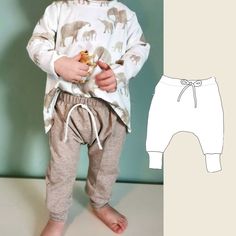 a little boy standing next to a paper cut out of his body and wearing sweatpants