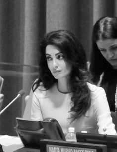 two women sitting at a table in front of microphones