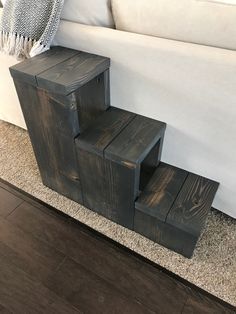 a white couch sitting next to a set of wooden steps on top of a hard wood floor