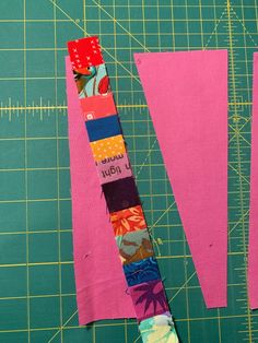 two pieces of fabric sitting on top of a cutting board