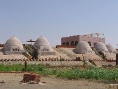 an old building in the middle of a desert with many domes on it's sides