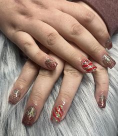 a woman's hands with red and gold nail polish