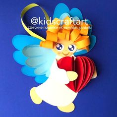 an origami angel holding a heart on a blue background with the words kidscraftart above it