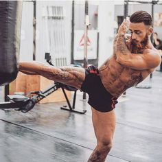 a man doing a kickbox pose in the middle of a crossfit gym