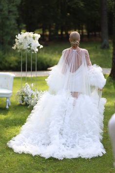 a woman in a wedding dress walking down the aisle with her veil over her head