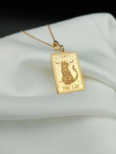 Embrace the mystical charm of our Cat Tarot Necklace, a dainty 14K gold piece that's perfect for cat lovers and tarot enthusiasts alike. This unique necklace features a delicately engraved cat design and a tiny tarot card charm, blending elegance with a touch of magic. ⚜️ Package included: One Handmade Necklace ⚜️ Pendant Sizes: 14 / 16 / 18 / 20 / 22 / 24 / 26 / 28 / 30 mm ⚜️ Necklace Length: 14 / 16 / 18 / 20 / 22 inches ⚜️ Materials: 925 Sterling Silver / Gold Plated / 14K Solid Gold FAQ: ✈️ Tarot Necklace, Spiritual Necklace, 14k Gold Necklace, Cat Necklace, Pet Necklace, Engraved Necklace, Gold Plated Necklace, Minimalist Necklace, Dainty Necklace