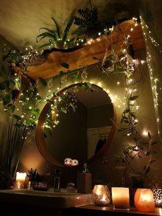 a mirror and some candles on a counter in a room with lights hanging from the ceiling