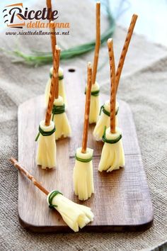 small pieces of cheese with toothpicks in them on a wooden cutting board, ready to be used as appetizers