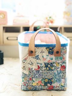 a handbag sitting on top of a table next to a drawer with drawers in the background