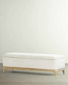 a white bench sitting on top of a hard wood floor