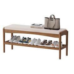 a wooden bench with several pairs of shoes on it and a tote bag next to it