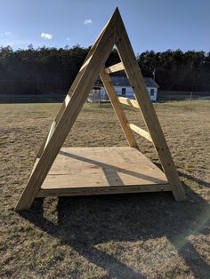 a wooden structure sitting in the middle of a field