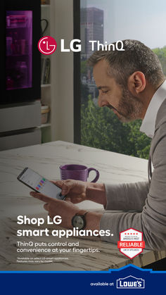 a man sitting at a table holding a tablet