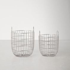 two metal baskets sitting next to each other on a white surface with no one in it