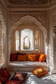 a white room with lots of pillows on the floor and windows in the wall behind it