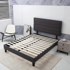 a bedroom with a bed, chair and nightstands in white and gray colors on the floor