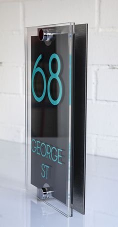 a glass sign that reads 66 george st in blue on the front and back of it