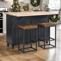 a kitchen island with two stools next to it and a christmas tree in the background