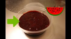 a plastic container filled with ketchup next to a watermelon slice on a table