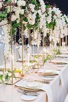 a long table with white flowers and place settings