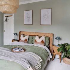 a bed room with a neatly made bed and two pictures on the wall above it