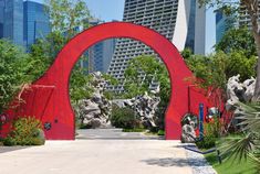 a large red arch in the middle of a park